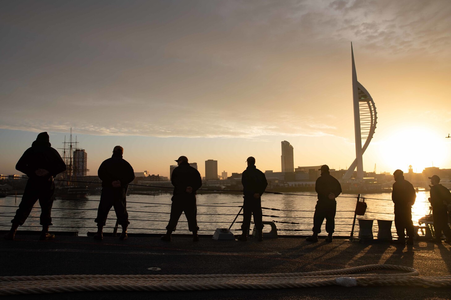 Sailors man the rails aboard the Arleigh Burke-class guided missile destroyer USS Thomas Hudner (DDG 116) as part of the Gerald R. Ford Carrier Strike Group, as the ship ports in Portsmouth, England on Nov. 14, 2022. The first-in-class aircraft carrier USS Gerald R. Ford (CVN 78) is on its inaugural deployment conducting training and operations alongside NATO Allies and partners to enhance integration for future operations and demonstrate the U.S. Navy’s commitment to a peaceful, stable and conflict-free Atlantic region. (U.S. Navy photo by Mass Communication Specialist 3rd Class Chelsea Palmer)