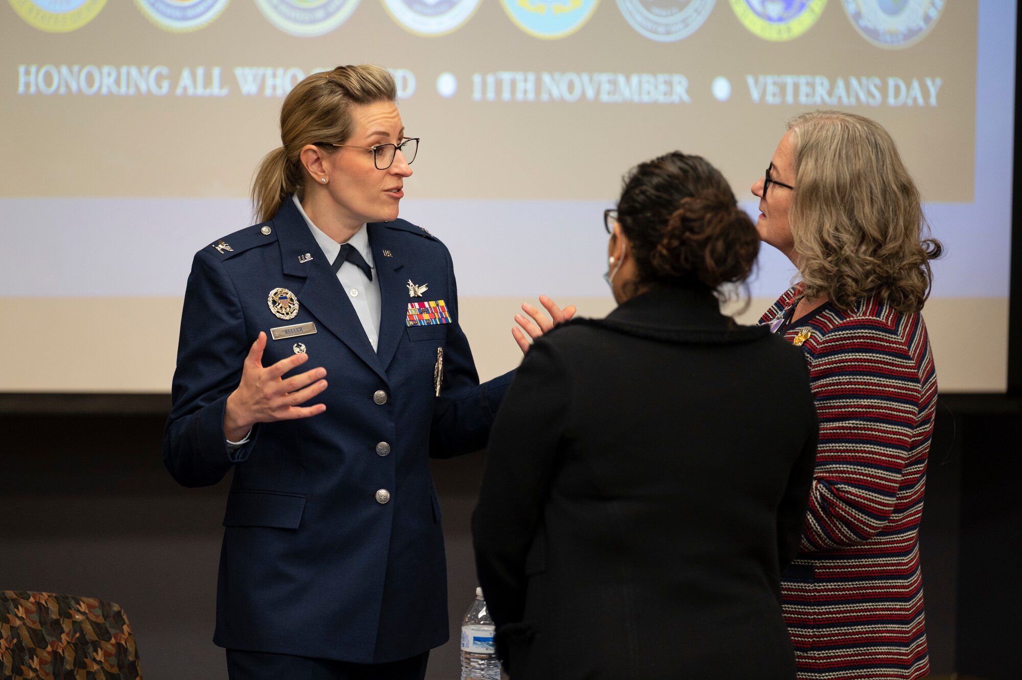 A woman speaks with a group of people.