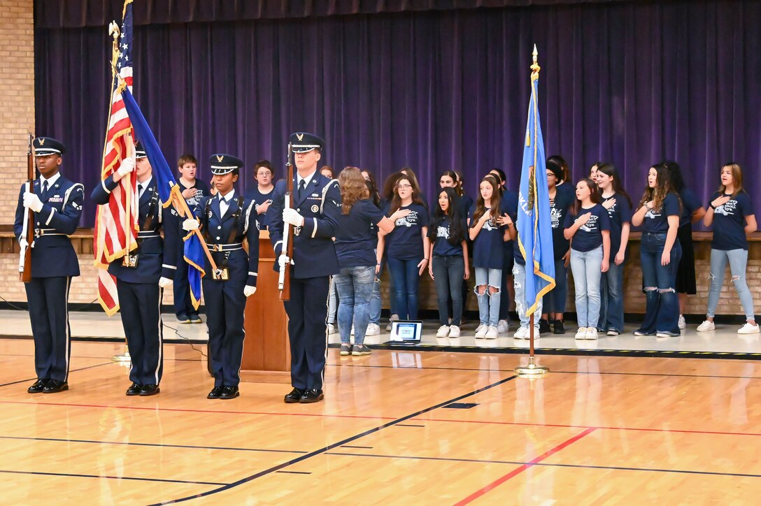 The Altus Junior High School (AJHS) choir sings the national anthem while the Blue Knights Honor Guard from Altus Air Force Base, Oklahoma, presents the colors at AJHS, Nov. 9, 2022. The Blue Knights Honor Guard attend multiple Altus events to help build partnerships between the community and base. (U.S. Air Force photo by Senior Airman Kayla Christenson)