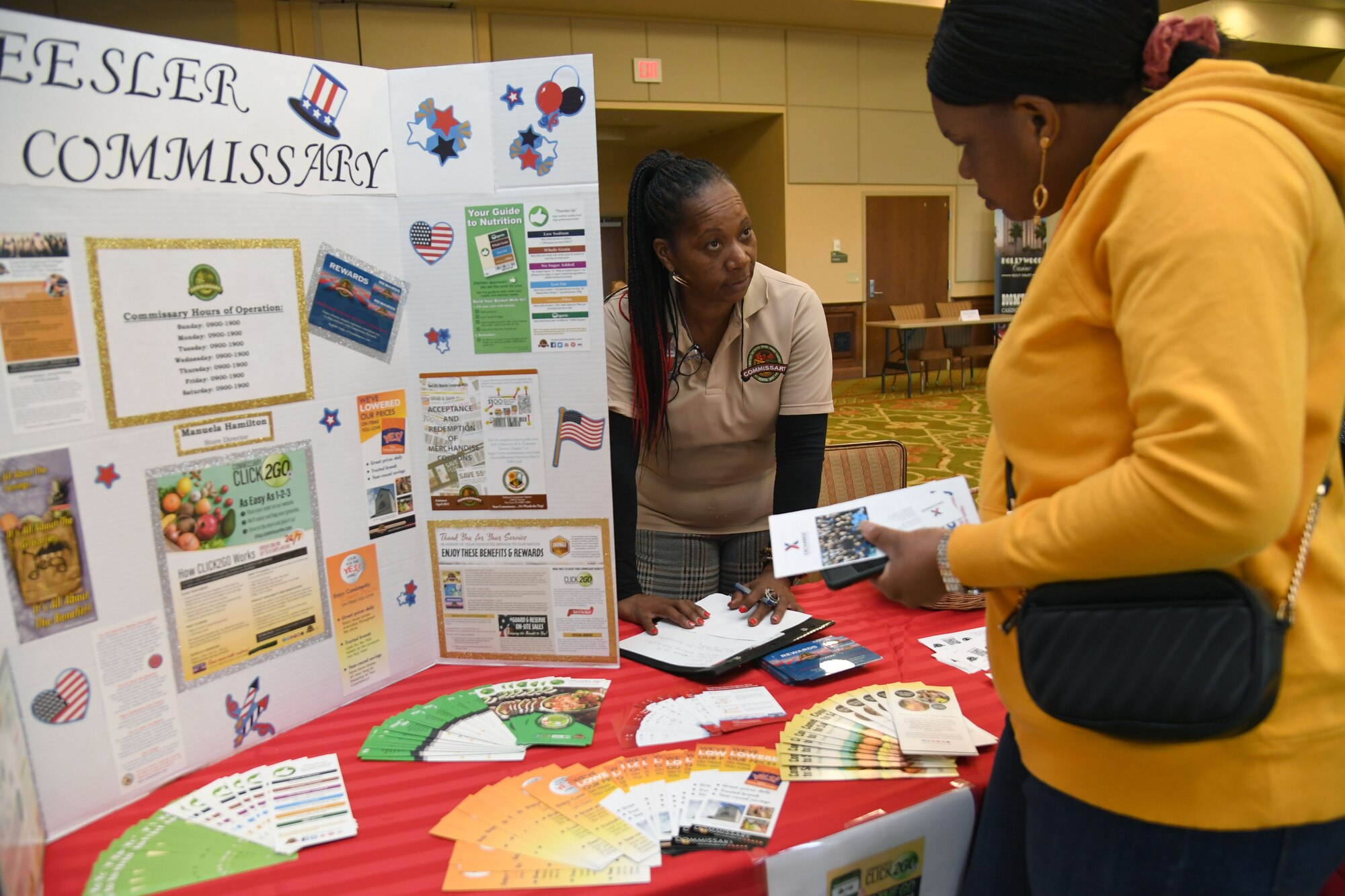 Angela Crawford, Keesler Commissary store manager, provides career information to Mariam Kone during the Keesler Job Fair inside the Bay Breeze Event Center at Keesler Air Force Base, Mississippi, Nov. 14, 2022.