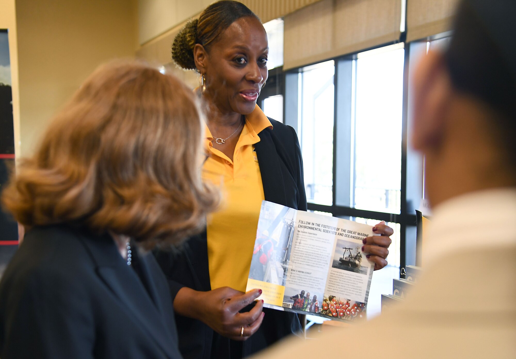 Mary Maner, University of Southern Mississippi career services assistant director, provides career information to Priscilla Williams and Kaitlyn Greer during the Keesler Job Fair inside the Bay Breeze Event Center at Keesler Air Force Base, Mississippi, Nov. 14, 2022.