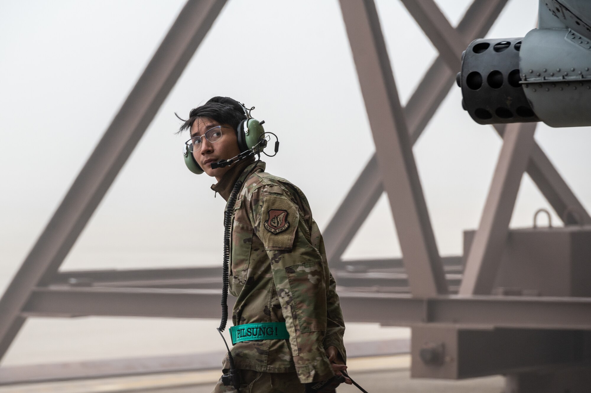 U.S. Air Force Staff Sgt. John-Michael Salenga, 25th Fighter Generation Squadron crew chief, moves into position to marshal an A-10C Thunderbolt II out of a hangar before takeoff in support of an agile combat employment (ACE) training sortie