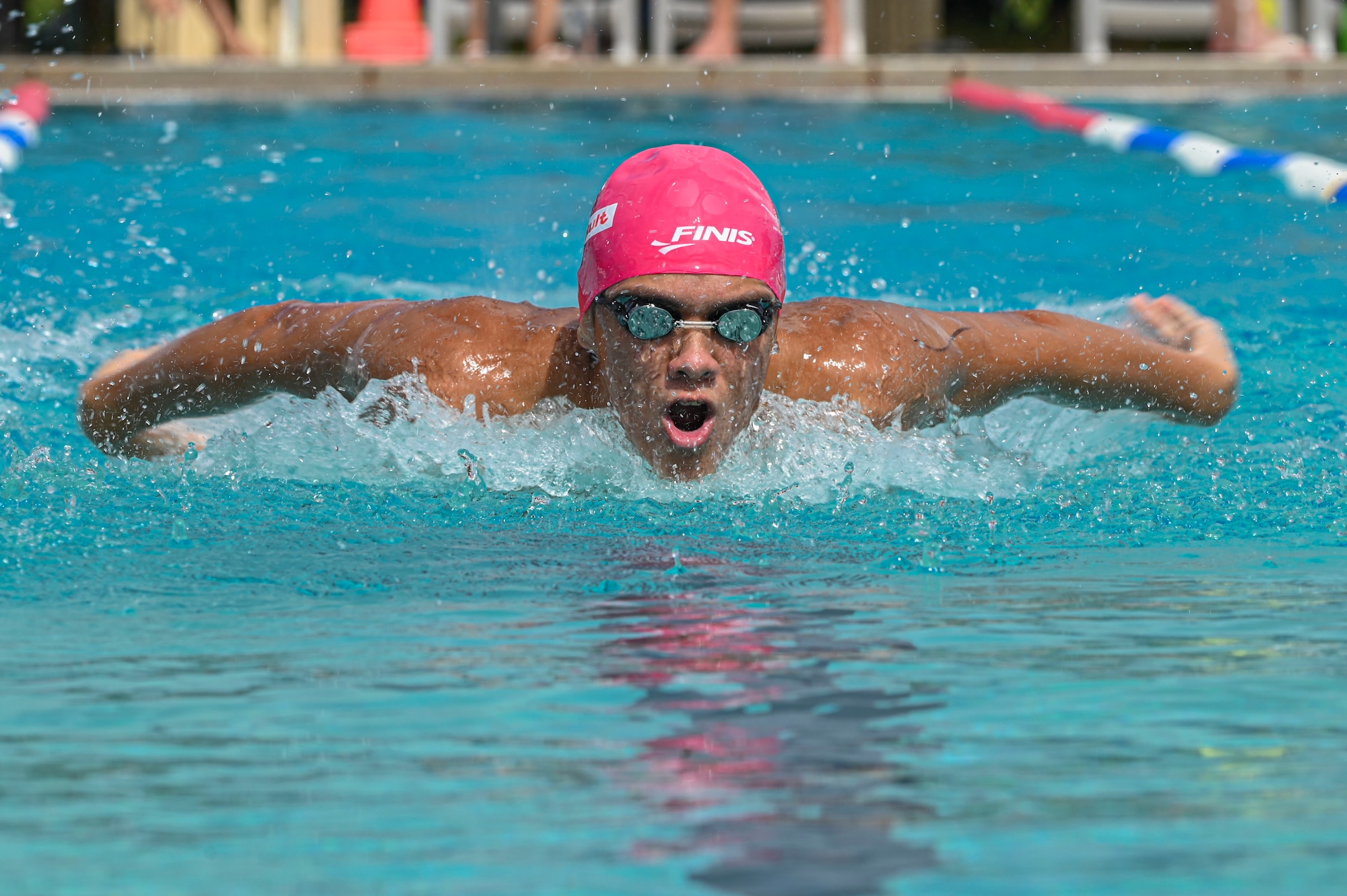 A swimmer swims butterfly.