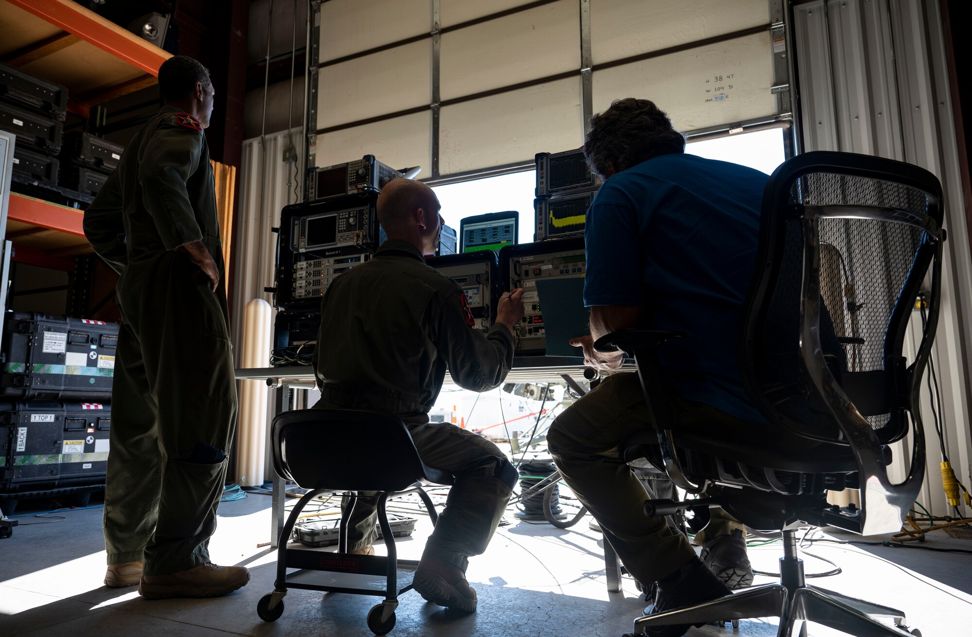 U.S. Air Force Lt. Col. Mike Johnson, 26th Space Aggressor Squadron space control operator, center, accesses a satellite via a system called the “Badger” during a CRIMSON SKIES exercise