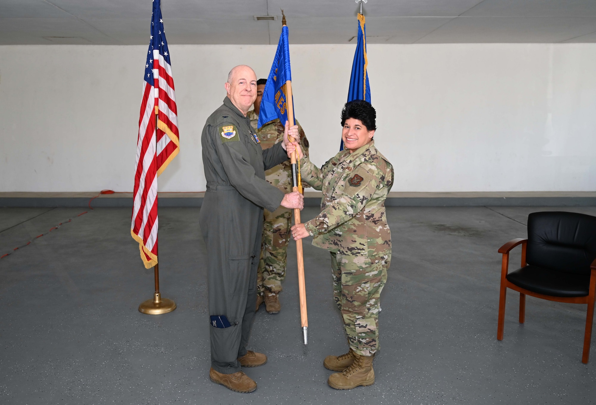 Col. James Miller, 433rd Operations Group commander, presents the 433rd Aeromedical Evacuation Squadron guidon to Col. Sylvia Fernandez during an assumption of command ceremony at Joint Base San Antonio-Lackland, Texas, Nov. 5, 2022. The 433rd AES provides aeromedical evacuation support when events like natural disasters and conflict occur, or anytime routine medical transportation by air is required. (U.S. Air Force photo by Tech. Sgt. Mike Lahrman)