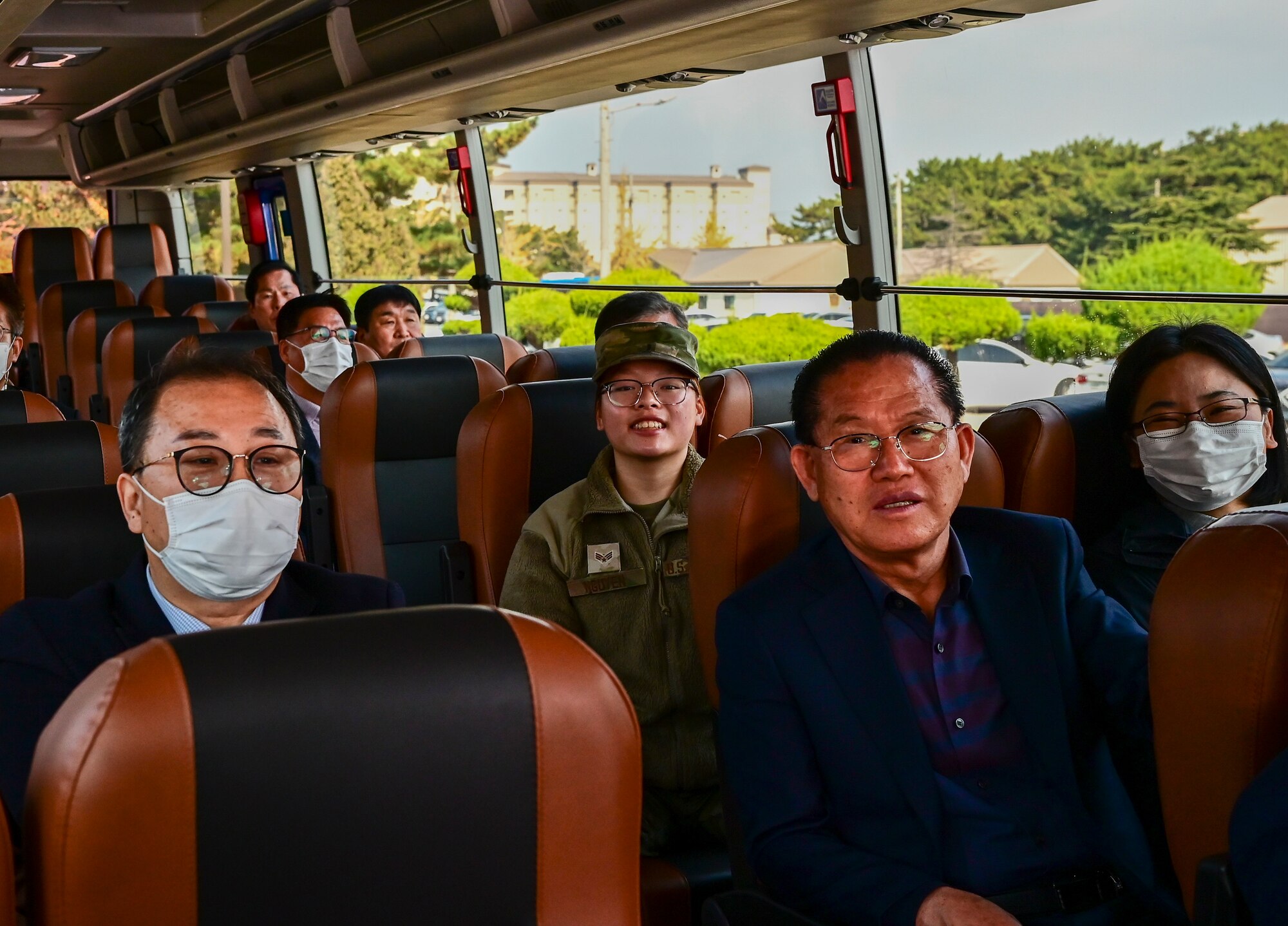 An Airman sits on a bus amongst various clergy members from across the Republic of Korea