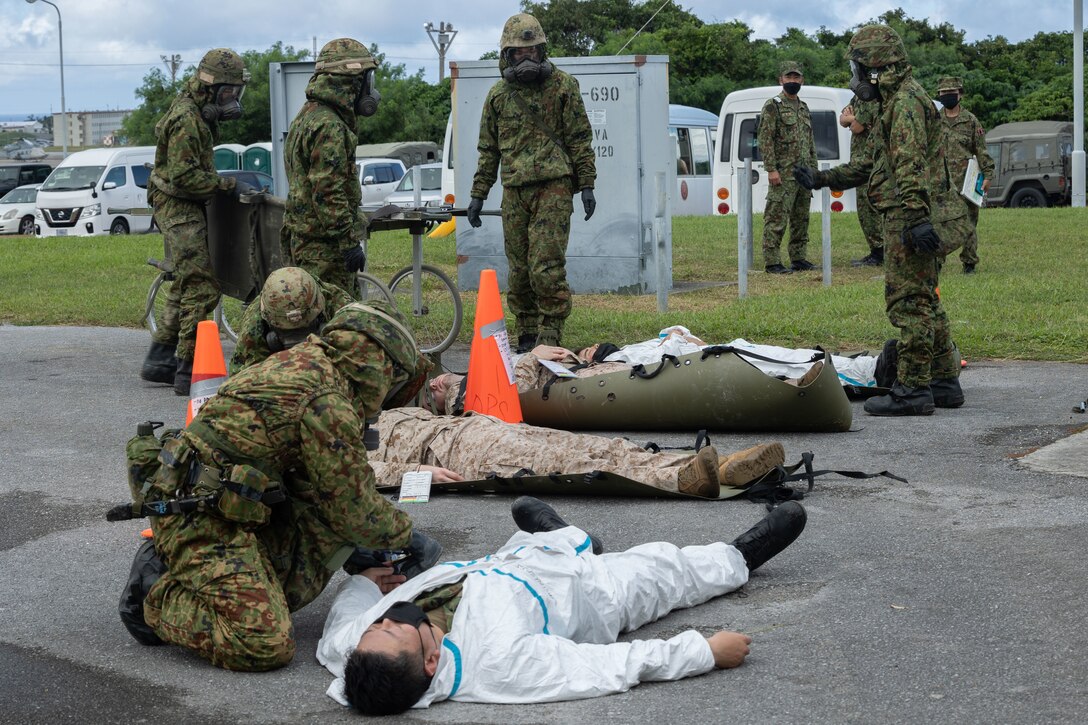 U.S. service members and members of the Japanese Ground Self Defense Force (JGSDF) conduct mass casualty training during a simulated chemical attack for exercise Keen Sword 23 at Marine Corps Air Station (MCAS) Futenma, Nov. 13, 2022. Keen Sword exercises the combined capabilities and lethality developed between the 1st Marine Aircraft Wing, III Marine Expeditionary Force, and the Japan Self Defense Force (JSDF). This bilateral field-training exercise between the U.S. military and JSDF strengthens interoperability and combat readiness of the U.S.-Japan Alliance. (U.S. Marine Corps photo by Lance Cpl. Emily Weiss)