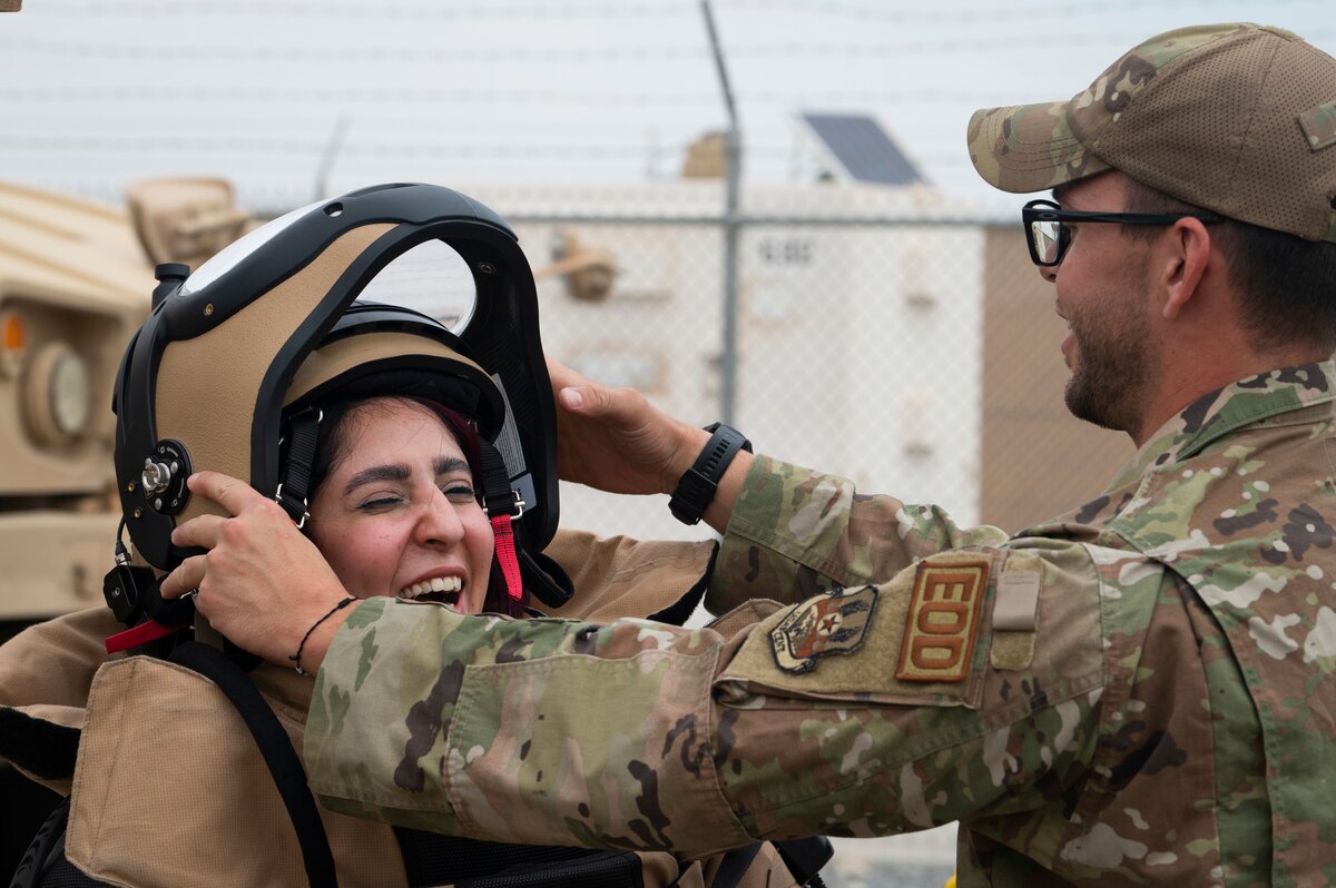 From right, U.S. Air Force Staff Sgt. Andrew Kekich, 386th Expeditionary Civil Engineer Squadron Explosive Ordnance Disposal journeyman, puts an EOD bomb suit on Mai Mahmoud Abbas Mahmoud, Al Qabas journalist, at Ali Al Salem Air Base, Kuwait, Nov. 14, 2022. Journalists were invited to the installation to see how the 386th AEW projects rapid global mobility and advances regional stability throughout the Middle East (U.S. Air Force photo by Staff Sgt. Dalton Williams)