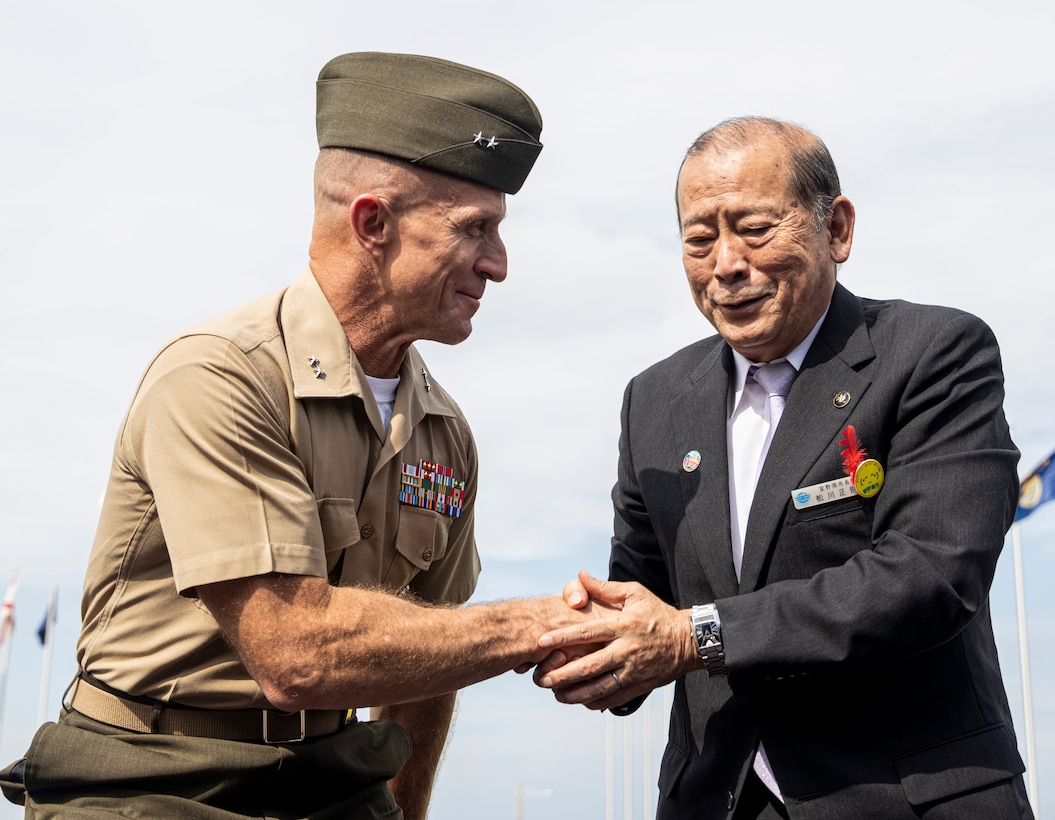 U.S. Marine Corps Maj. Gen. Stephen E. Liszewski, left, the commanding general of Marine Corps Installations Pacific, shakes hands with Masanori Matsugawa, right, the mayor of Ginowan, Okinawa, after signing a Local Implementing Agreement on Camp Foster, Okinawa, Japan, Nov. 7, 2022. The LIA for limited disaster preparedness allows evacuees a quick and direct passage to higher ground or shelter on participating Marine Corps bases immediately before, during or following a natural disaster. The signing signifies a critical step to safeguard the citizens of local communities and reaffirms the commitment of the U.S. to assist Japan in the event of a natural disaster. (U.S. Marine Corps photo by Cpl. Alex Fairchild)