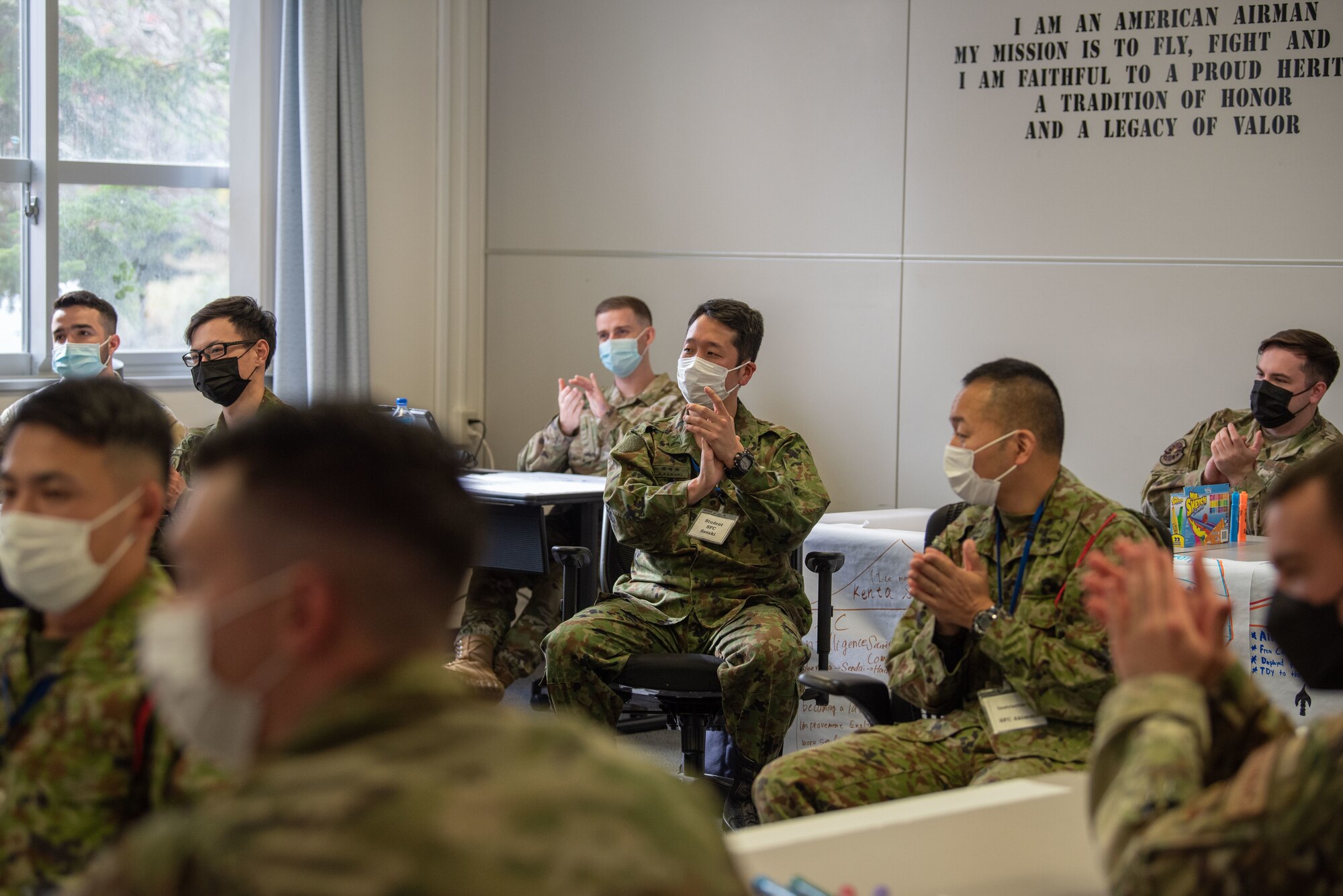 U.S. Airmen and Japan Ground Self-Defense Force (JGSDF) soldiers applaud after a participant speaks in an icebreaker event during Camp Sendai’s Basic English Training Course tour of the Airman Leadership School at Misawa Air Base, Japan, Nov. 8, 2022.