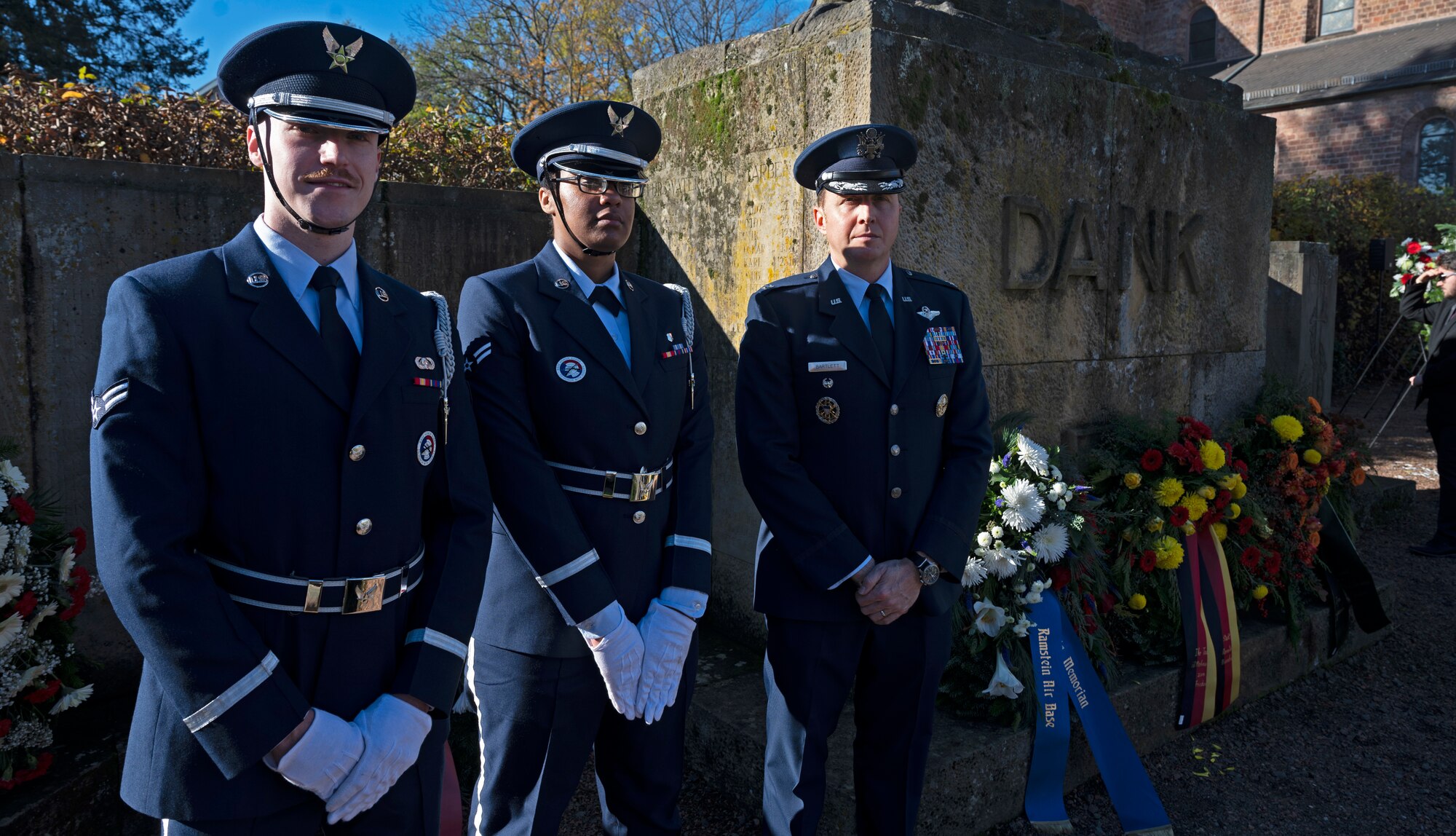 U.S. Air Force Col. Matthew Bartlett, 435th Air Expeditionary Wing vice commander, and members from the 86th Airlift Wing Honor Guard stand in front of a memorial in the Union Community of  Ramstein-Miesenbach, Germany Nov. 13, 2022 during a National Day of Mourning ceremony. Bartlett represented Ramstein at the ceremony, which honors those who have perished in wars from all nations. (U.S. Air Force photo by Senior Airman Thomas Karol)