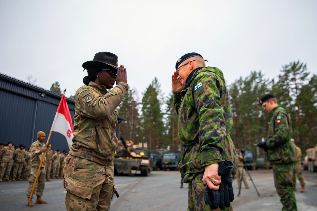 A Finnish senior officer salutes a U.S. senior officer.