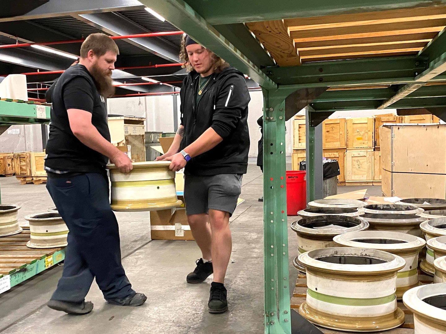 Two men carry a cylinder-shaped object