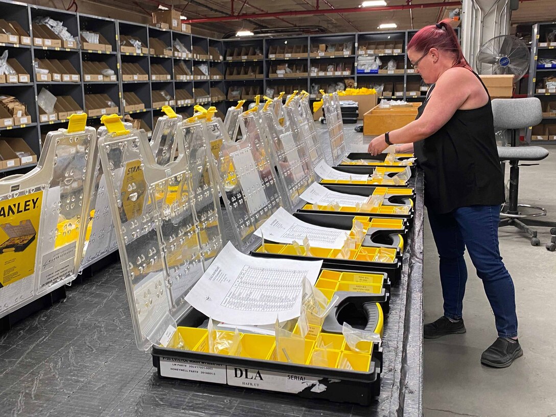 A woman places like items together in a warehouse