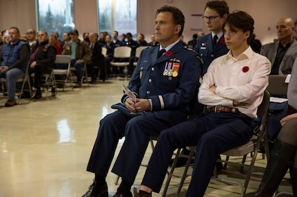 Canadian Armed Forces Brig. Gen. William Radiff, North American Aerospace Defense Command Region deputy commander, with his son, honored veterans during the  Department of Military and Veterans Affairs Veterans Day ceremony held at the National Guard Armory on Joint Base Elmendorf-Richardson, Alaska, Nov. 11, 2022. The ceremony included speeches from key speakers, Fallen Warrior ceremony, presentation of commemorative wreaths, and moment of silence for those who have fallen. (Alaska National Guard photo by Victoria Granado)