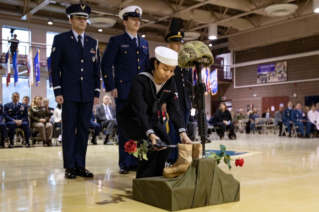 Contruction Mechanic 2nd Class Christiana Gadston, a Naval Militia Sailor with the Joint Forces Honor Guard, lays roses during the Fallen Warrior Ceremony for the  Department of Military and Veterans Affairs Veterans Day ceremony held at the National Guard Armory on Joint Base Elmendorf-Richardson, Alaska, Nov. 11, 2022. The ceremony included speeches from key speakers, Fallen Warrior ceremony, presentation of commemorative wreaths, and moment of silence for those who have fallen. (Alaska National Guard photo by Victoria Granado)