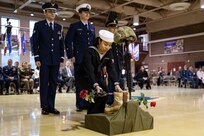 Contruction Mechanic 2nd Class Christiana Gadston, a Naval Militia Sailor with the Joint Forces Honor Guard, lays roses during the Fallen Warrior Ceremony for the  Department of Military and Veterans Affairs Veterans Day ceremony held at the National Guard Armory on Joint Base Elmendorf-Richardson, Alaska, Nov. 11, 2022. The ceremony included speeches from key speakers, Fallen Warrior ceremony, presentation of commemorative wreaths, and moment of silence for those who have fallen. (Alaska National Guard photo by Victoria Granado)