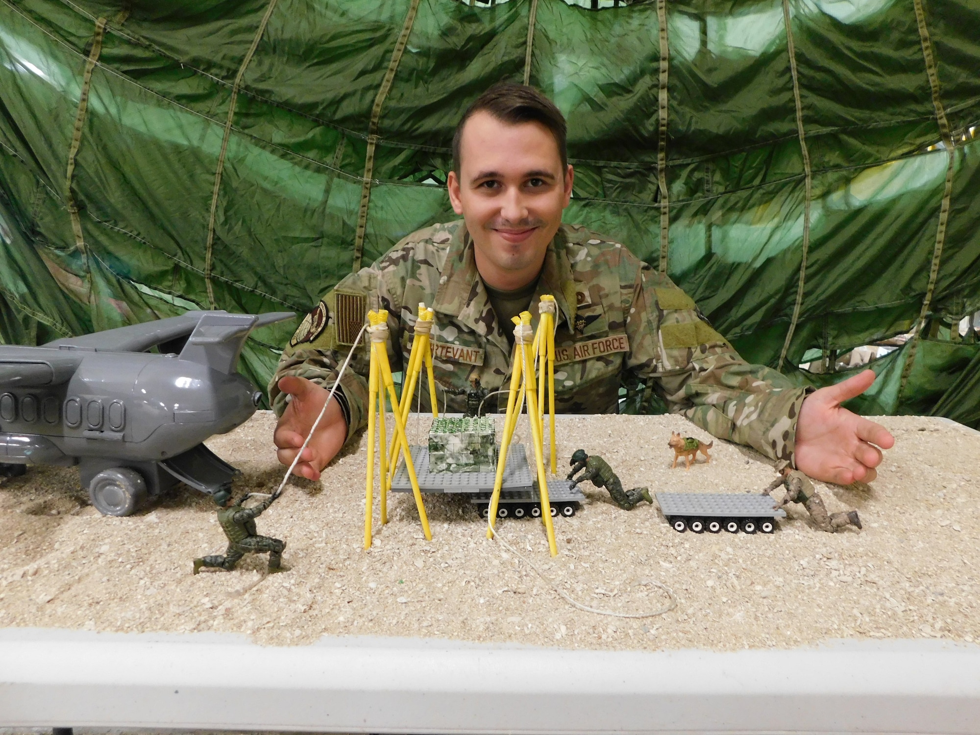 Staff Sgt. Michael Sturtevant, air transportation and aerial delivery supervisor, displays a model of his 2022 Spark Tank submission Project OREGON TRAIL, which was one of two finalists selected for Air Force Special Operation Command, at Kadena Air Base, Japan, Nov. 2, 2022. Sturtevant’s Project OREGON TRAIL aims to create a quick and space-reducing solution for moving pallets and equipment in austere environments in lieu of a forklift. (U.S. Air Force photo by Staff Sgt. Demond Mcghee)