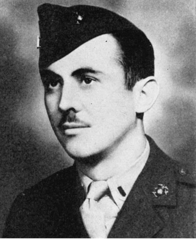 A man in a military cap and uniform poses for a photo.