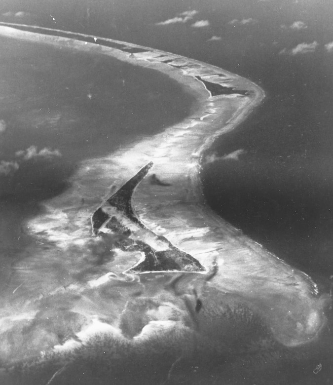 A black-and-white aerial photograph of islands within an atoll.