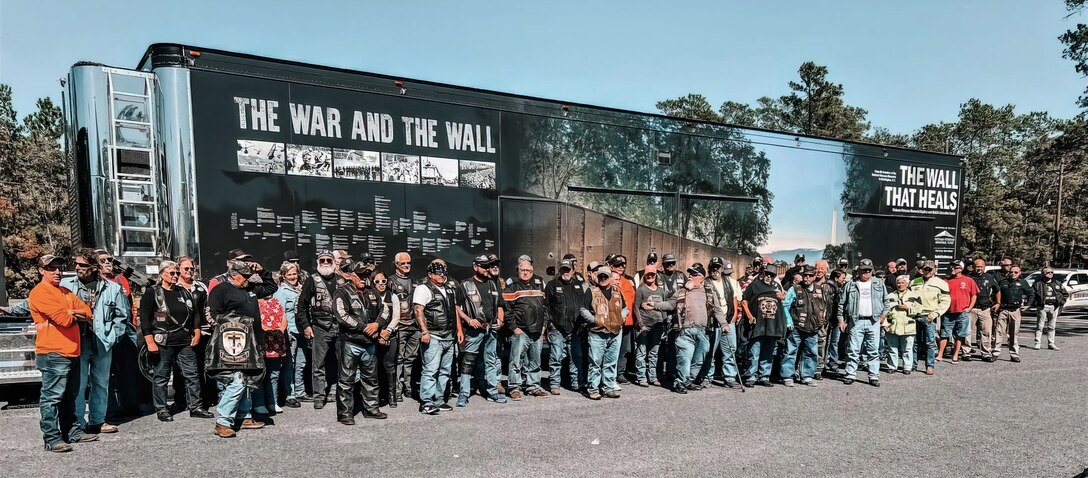 Vietnam War veterans gather for a group photo at the Wall That Heals - Chambers County exhibit late October 2022 in Anahuac, Texas.t 350 feet long, and with its largest panel 7.5 feet high, this synthetic granite structure bears the names of the 58,281 men and women who made the ultimate sacrifice in Vietnam. More than 4,500 people visited the memorial while on display in Anahuac. The traveling exhibit will appear in 29 communities throughout the country this year. (Photo courtesy of Wall That Heals - Chamber County) (photo courtesy of Wall That Heals - Chambers County)