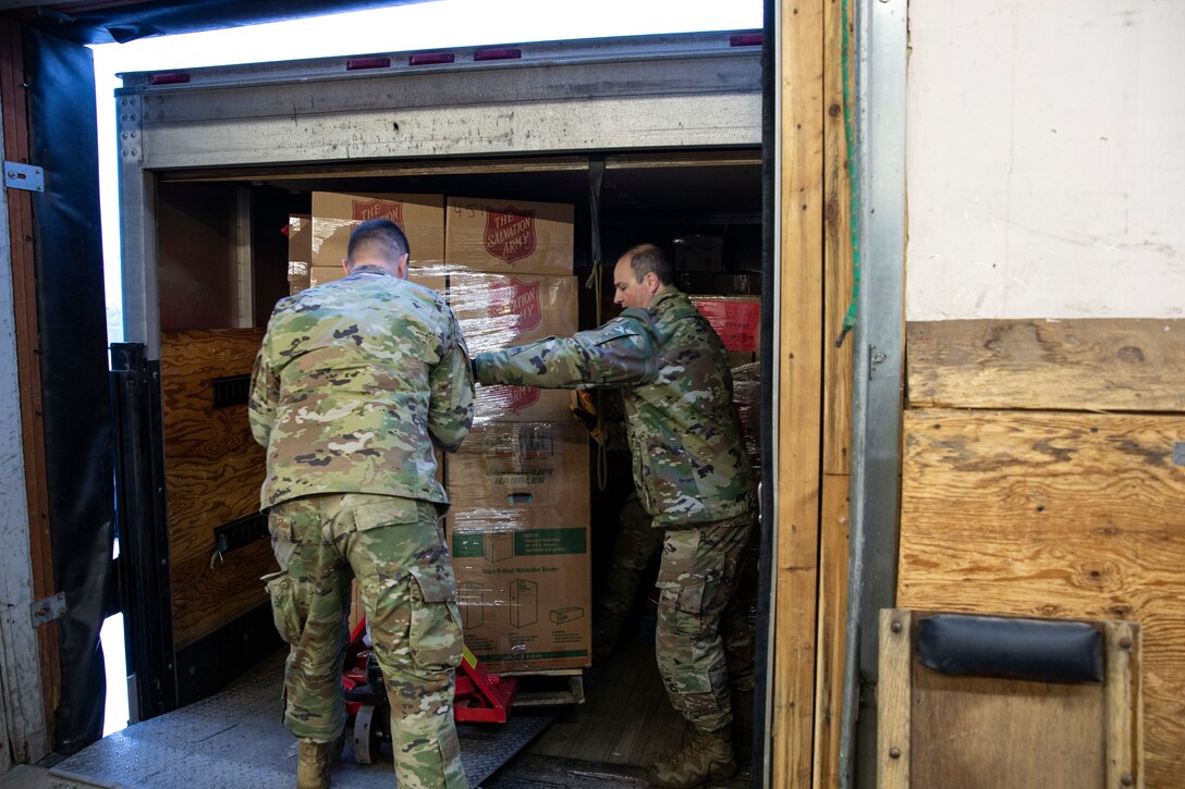 Tech. Sgt. Michael Durgin (left), a ground transportation specialist with 176th Logistics Readiness Squadron, 176th Wing and Master Sgt. Garrick Hoehne, a logistics planner with 176th Logistics Readiness Squadron, 176th Wing guide a pallet of gifts for Operation Santa Claus onto a truck at the Salvation Army warehouse in Anchorage, Alaska, Nov. 10, 2022. Operation Santa Claus is the AKNG’s yearly community relations and support program that provides gifts to children in remote communities across the state. In its 67th year, the program will celebrate with the communities of Scammon Bay, Minto and Nuiqsuit. (Alaska National Guard photo by Staff Sgt. Katie Mazos-Vega)