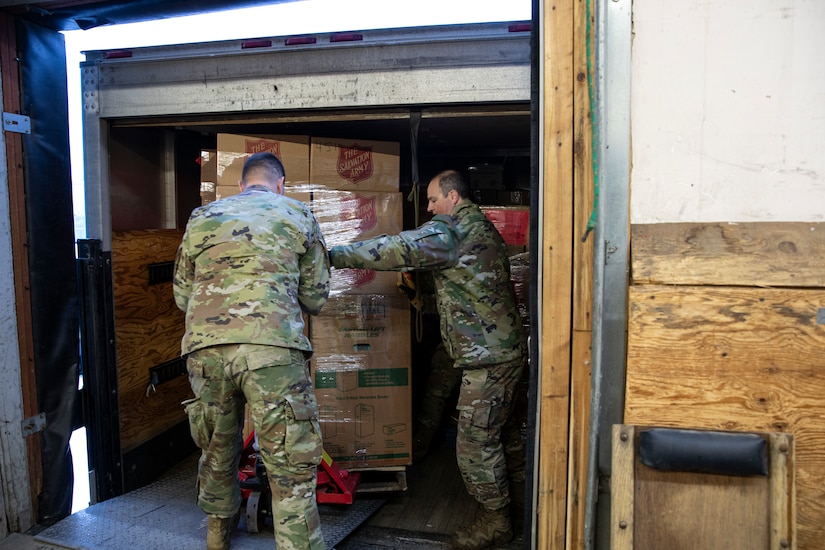 Tech. Sgt. Michael Durgin (left), a ground transportation specialist with 176th Logistics Readiness Squadron, 176th Wing and Master Sgt. Garrick Hoehne, a logistics planner with 176th Logistics Readiness Squadron, 176th Wing guide a pallet of gifts for Operation Santa Claus onto a truck at the Salvation Army warehouse in Anchorage, Alaska, Nov. 10, 2022. Operation Santa Claus is the AKNG’s yearly community relations and support program that provides gifts to children in remote communities across the state. In its 67th year, the program will celebrate with the communities of Scammon Bay, Minto and Nuiqsuit. (Alaska National Guard photo by Staff Sgt. Katie Mazos-Vega)
