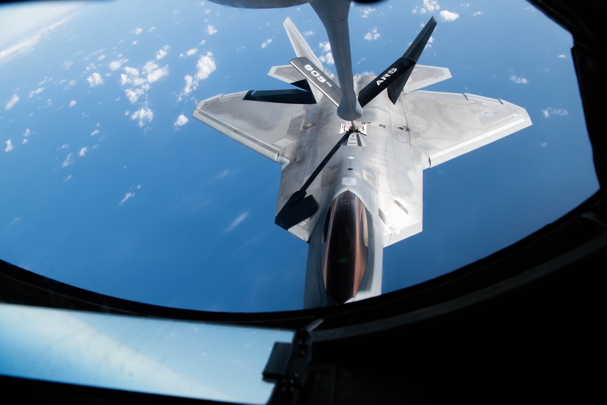 A fighter jet performs aerial refueling.