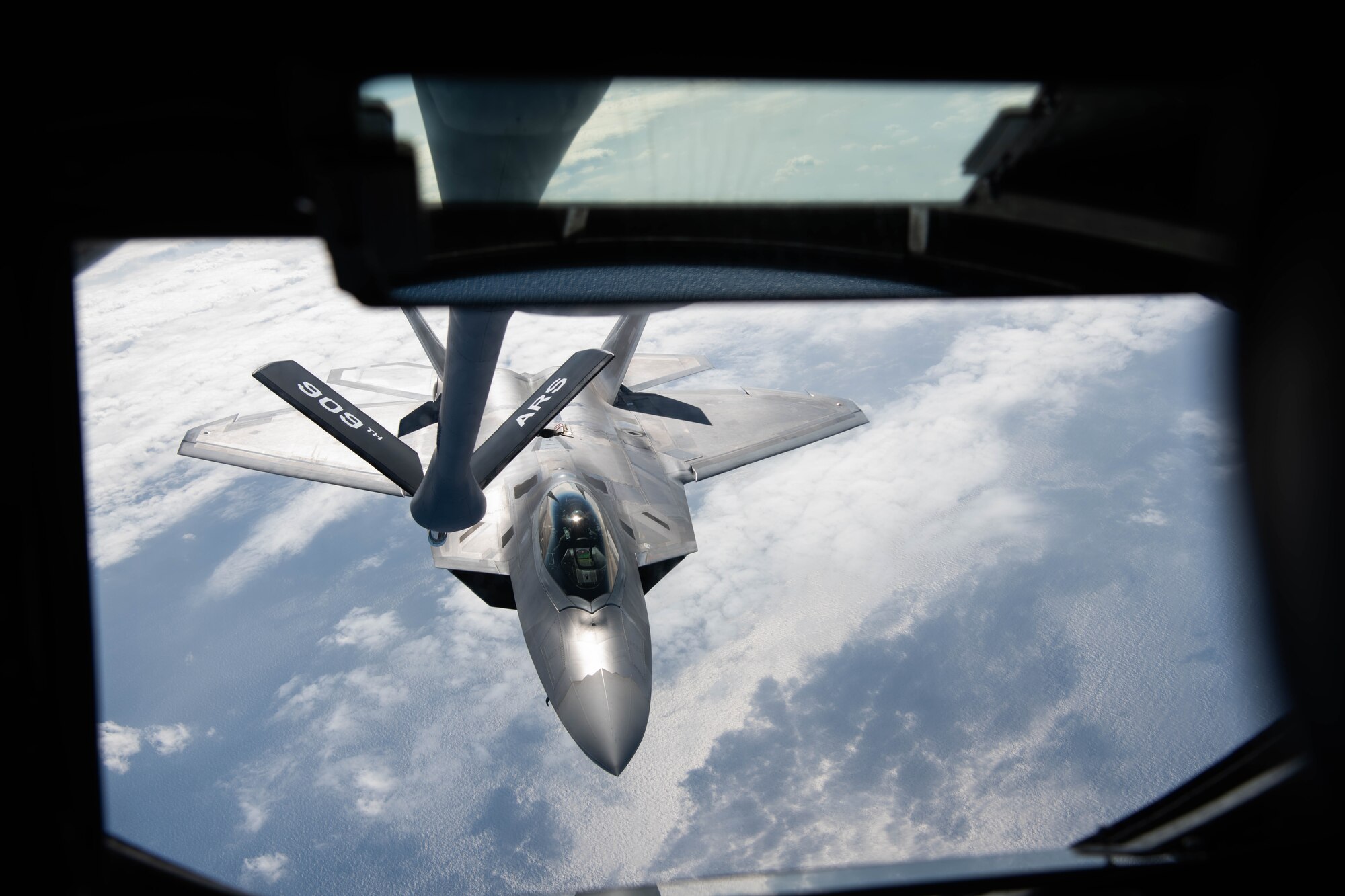 A fighter jet performs aerial refueling.