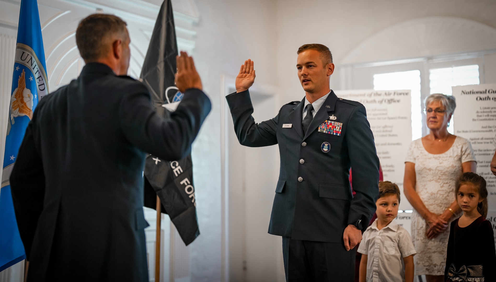 With right hand raised, an Air Force Officer repeats the Oath of Office during a ceremony.