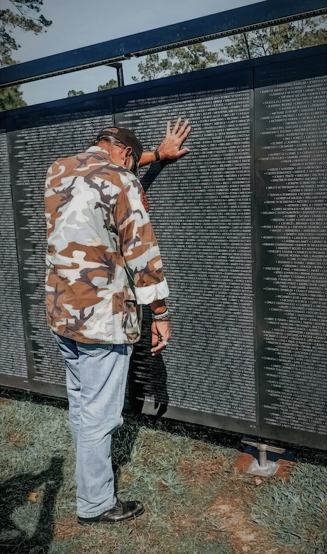During the opening day of the Wall That Heals =Chambers County exhibit Oct. 26, 2022, in Anahuac, Texas, a Vietnam War veteran places his hand on one of several synthetic granite panels that together bear the names of the 58,281 men and women who made the ultimate sacrifice in Vietnam. The Wall that Heals, which finished its 27th season Nov. 10, is a traveling exhibition that includes a three-quarter scale replica of the Vietnam Veterans Memorial in Washington, D.C. Anahuac was one of 29 communities selected to display the memorial this year. (Photo courtesy of Wall That Heals - Chambers County)