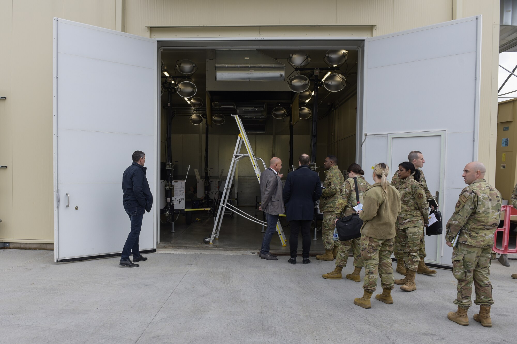 Multiple people look into a warehouse from outdoors