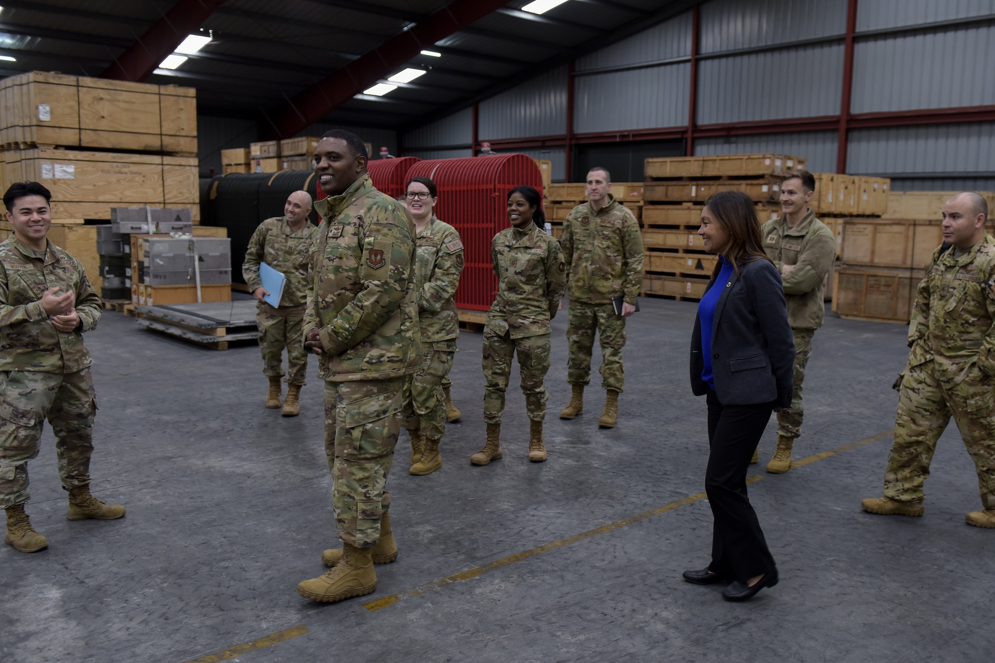 Multiple people smile while taking a tour of a warehouse