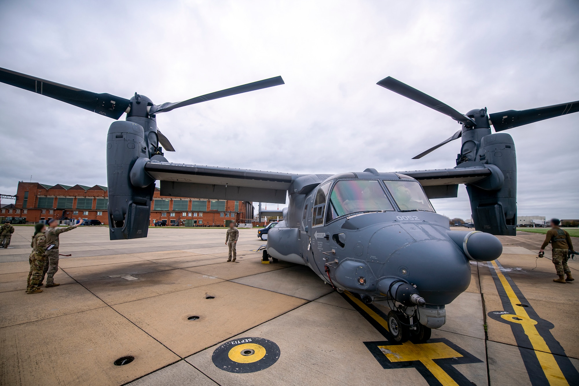 Airmen from the 352d Special Operations Wing inspect a CV-22B Osprey at RAF Mildenhall, England, Nov. 11, 2022. The 352d SOW were preparing to conduct a flyover for the annual Veterans Day ceremony at Cambridge American Cemetery and Memorial. (U.S. Air Force photo by Staff Sgt. Eugene Oliver)