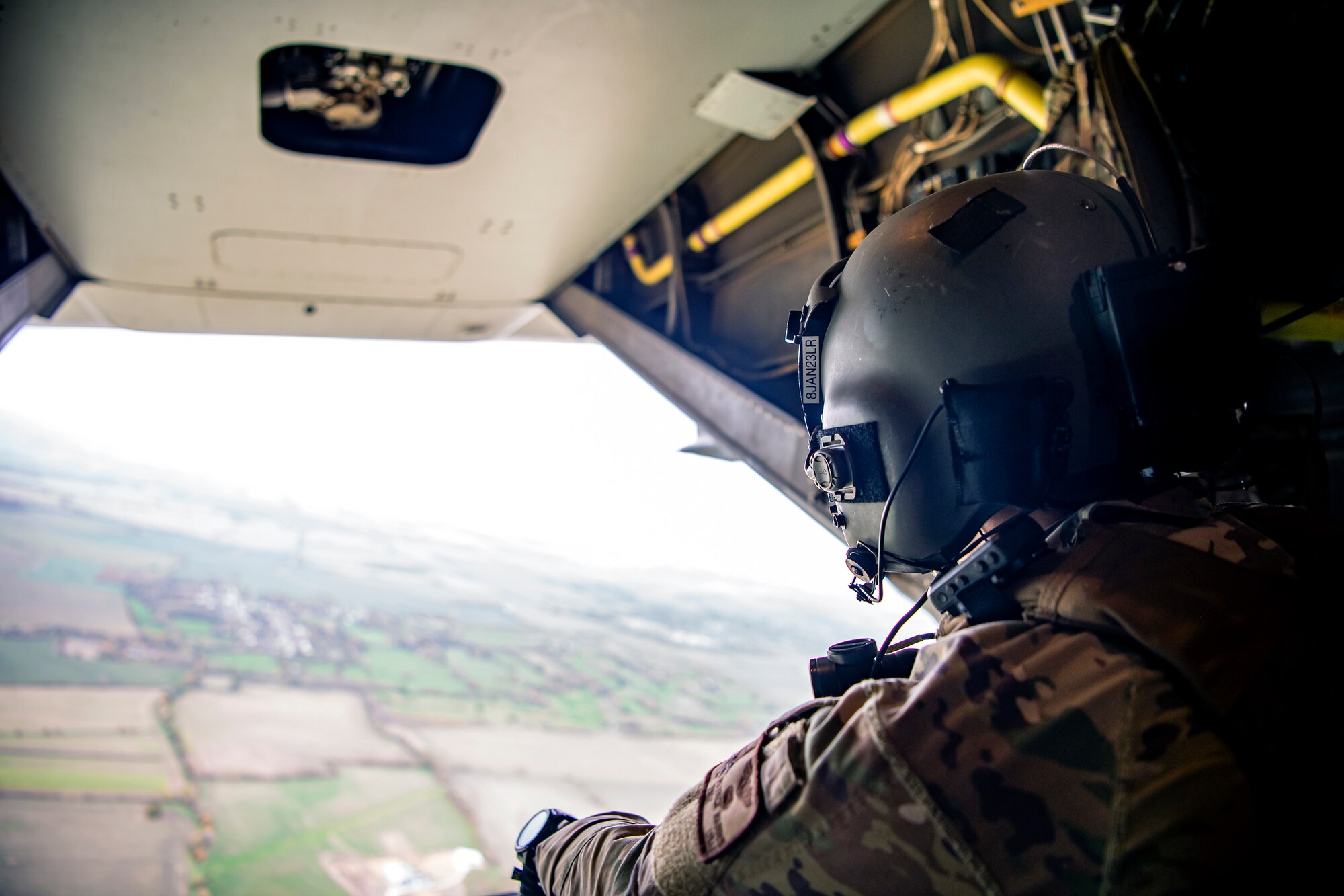 An Special Missions Aviator from the 352d Special Operations Wing looks out the back of a CV-22B Osprey as it flies over Cambridge, England, Nov. 11, 2022. The 352d SOW conducted a flyover for the annual Veterans Day ceremony at Cambridge American Cemetery and Memorial. (U.S. Air Force photo by Staff Sgt. Eugene Oliver)