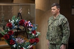 Commander Shawn William stands with the wreath meant as a remembrance for the fallen veterans during Naval Surface Warfare Center, Philadelphia Division’s Veterans Day and U.S. Marine Corps Birthday Observance on Nov. 9, 2022. (U.S. Navy Photo by Jermaine Sullivan/Released)