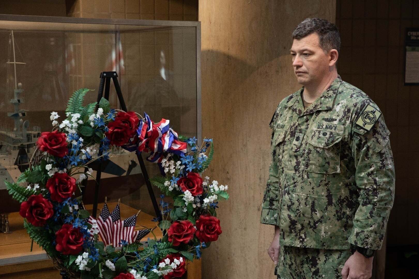 Commander Shawn William stands with the wreath meant as a remembrance for the fallen veterans during Naval Surface Warfare Center, Philadelphia Division’s Veterans Day and U.S. Marine Corps Birthday Observance on Nov. 9, 2022. (U.S. Navy Photo by Jermaine Sullivan/Released)