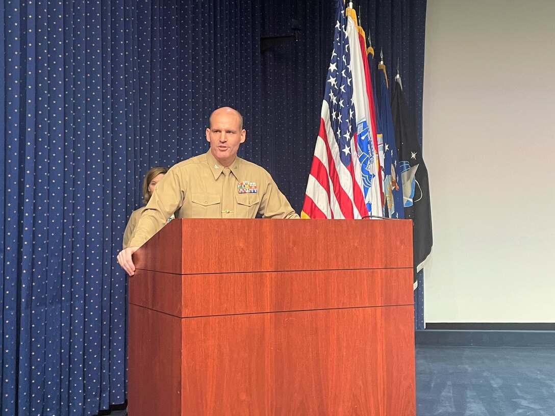 Marine addressed crowd at a podium.