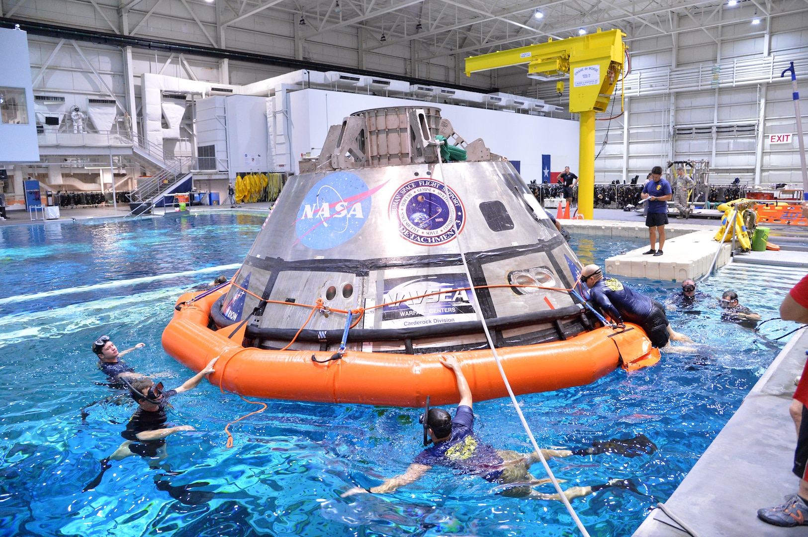 Navy divers, Air Force pararescuemen and Coast Guard rescue swimmers practice Orion recovery techniques at the Neutral Buoyancy Laboratory (NBL) at the agency’s Johnson Space Center in Houston on Sept. 21, 2016. The recovery team is practicing underway recovery techniques using a test version of the Orion spacecraft that was built by Naval Surface Warfare Center, Carderock Division. The Ground Systems Development and Operations Program, along with the U.S. Navy and Lockheed Martin, are preparing the recovery team, hardware and operations to support EM-1 recovery. (NASA photo by James Blair)