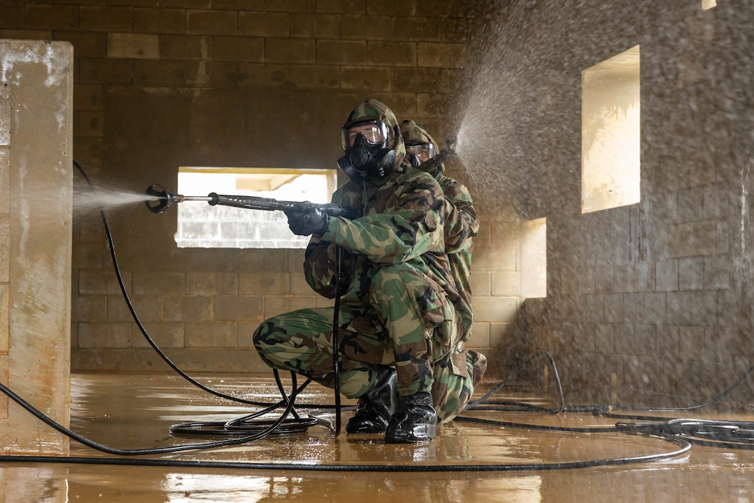 U.S. Marine Corps Lance Cpl. Carter Mailloux, front, and Lance Cpl. Blaize Benton, back, both chemical, biological, radiological, and nuclear specialists with 3rd Marine Logistics Group decontaminate a building during Keen Sword 23, Central Training Area, Okinawa, Japan, Nov. 14, 2022. Keen Sword exercises the combined capabilities and lethality developed between the 1st Marine Aircraft Wing, III Marine Expeditionary Force, and the Japan Self Defense Force. This bilateral field-training exercise between the U.S. military and JSDF strengthens interoperability and combat readiness of the U.S.-Japan Alliance.