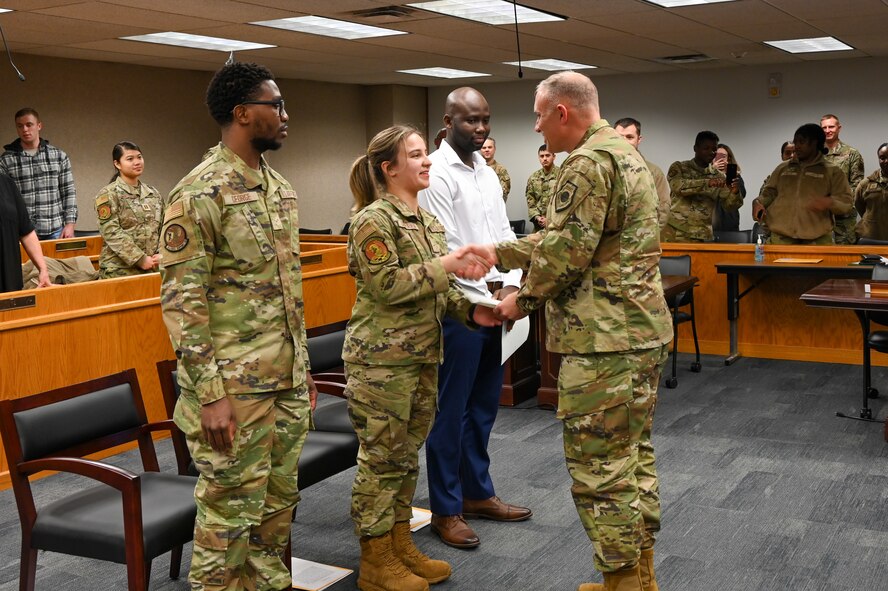 Airman 1st Class Jarious George from the 5th Force Support Squadron, Airman 1st Class Kojo Affainie and Airman Constanza De Puerta, from the 5th Logistics Readiness Squadron, earn their United States citizenship during a naturalization ceremony, Nov. 15, 2022, at Minot Air Force Base, North Dakota. During the ceremony, the Airmen were presented with their Certificates of Naturalization, making them U.S. citizens by law. (U.S. Air Force photo by Senior Airman Zachary Wright)