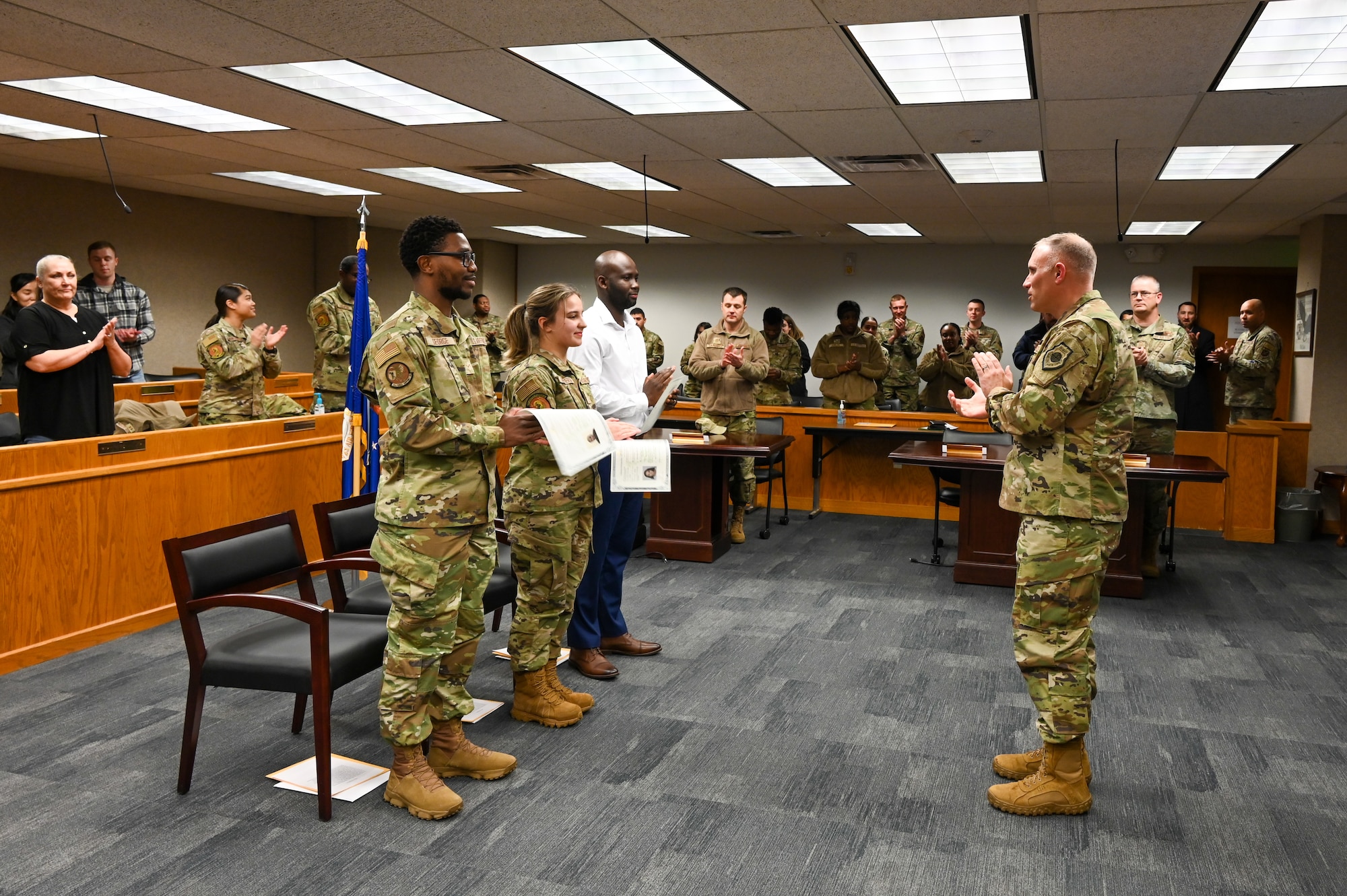 Airman 1st Class Jarious George from the 5th Force Support Squadron, Airman 1st Class Kojo Affainie and Airman Constanza De Puerta, from the 5th Logistics Readiness Squadron, earn their United States citizenship during a naturalization ceremony, Nov. 15, 2022, at Minot Air Force Base, North Dakota. During the ceremony, the Airmen were presented with their Certificates of Naturalization, making them U.S. citizens by law. (U.S. Air Force photo by Senior Airman Zachary Wright)