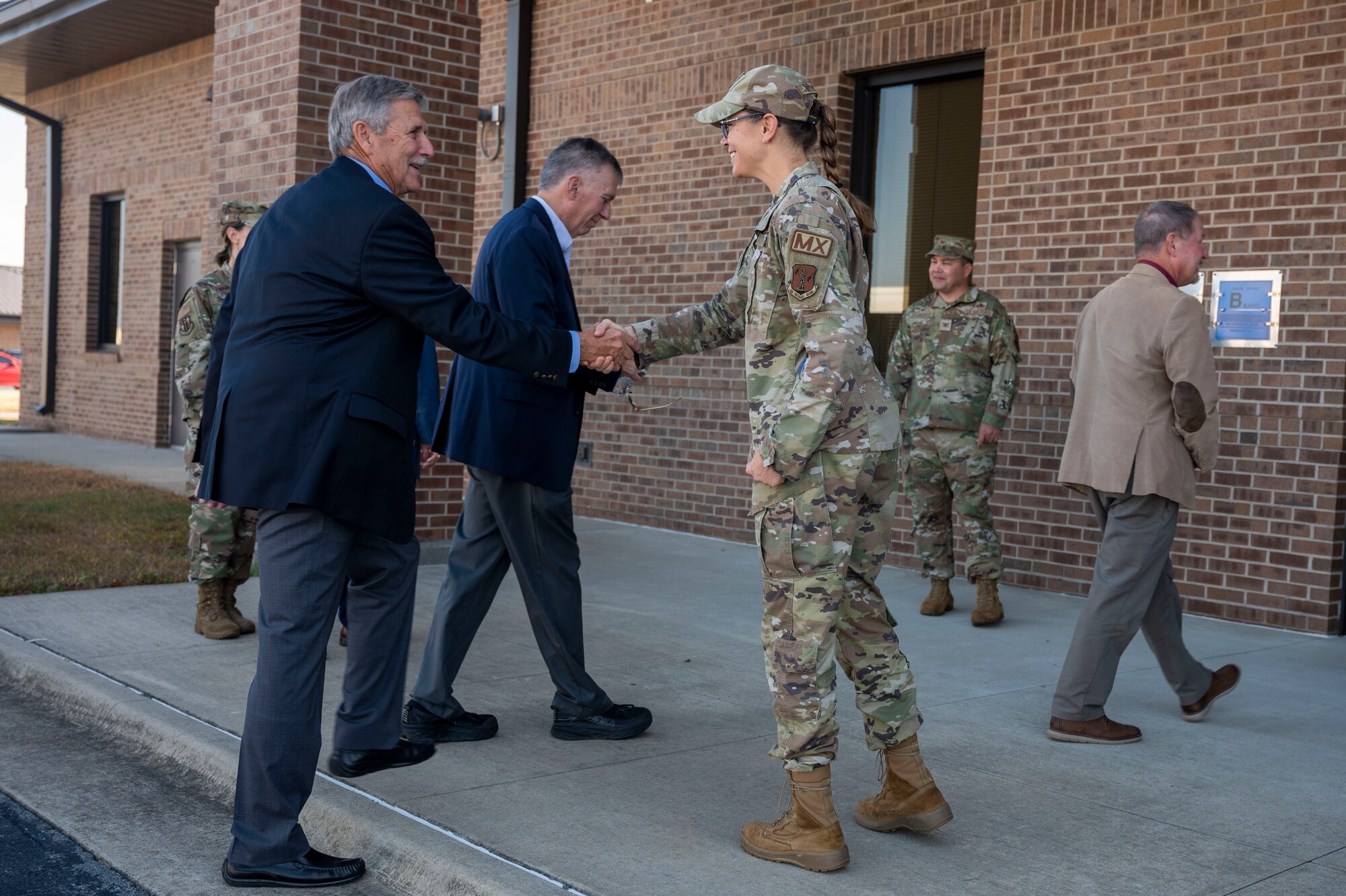 A man shakes hands with a woman in uniform