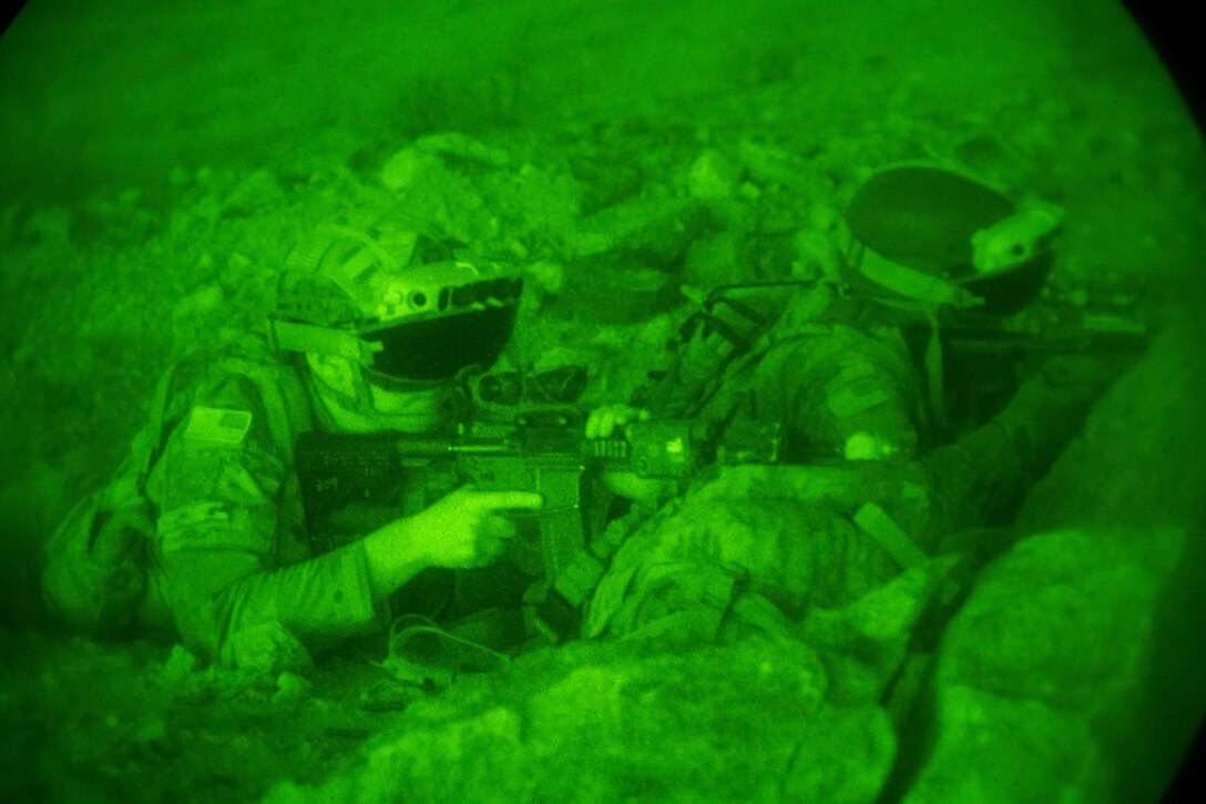 Soldiers use night vision goggles while training.