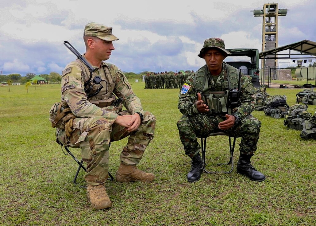Staff Sgt. Nate Myers, of Hartsville, Tennessee, a squad leader assigned to Bravo Company, 2nd Battalion, 130th Infantry Regiment, 33rd Infantry Brigade Combat Team, Illinois National Guard and Colombian Army Staff Sgt. Octavio Munoz, a platoon sergeant assigned to the BRNCA 1 Special Anti-Drug Brigade, share stories while taking a break from training during Exercise Southern Vanguard 23 at Tolemaida Military Base, Colombia on Nov. 10, 2022.