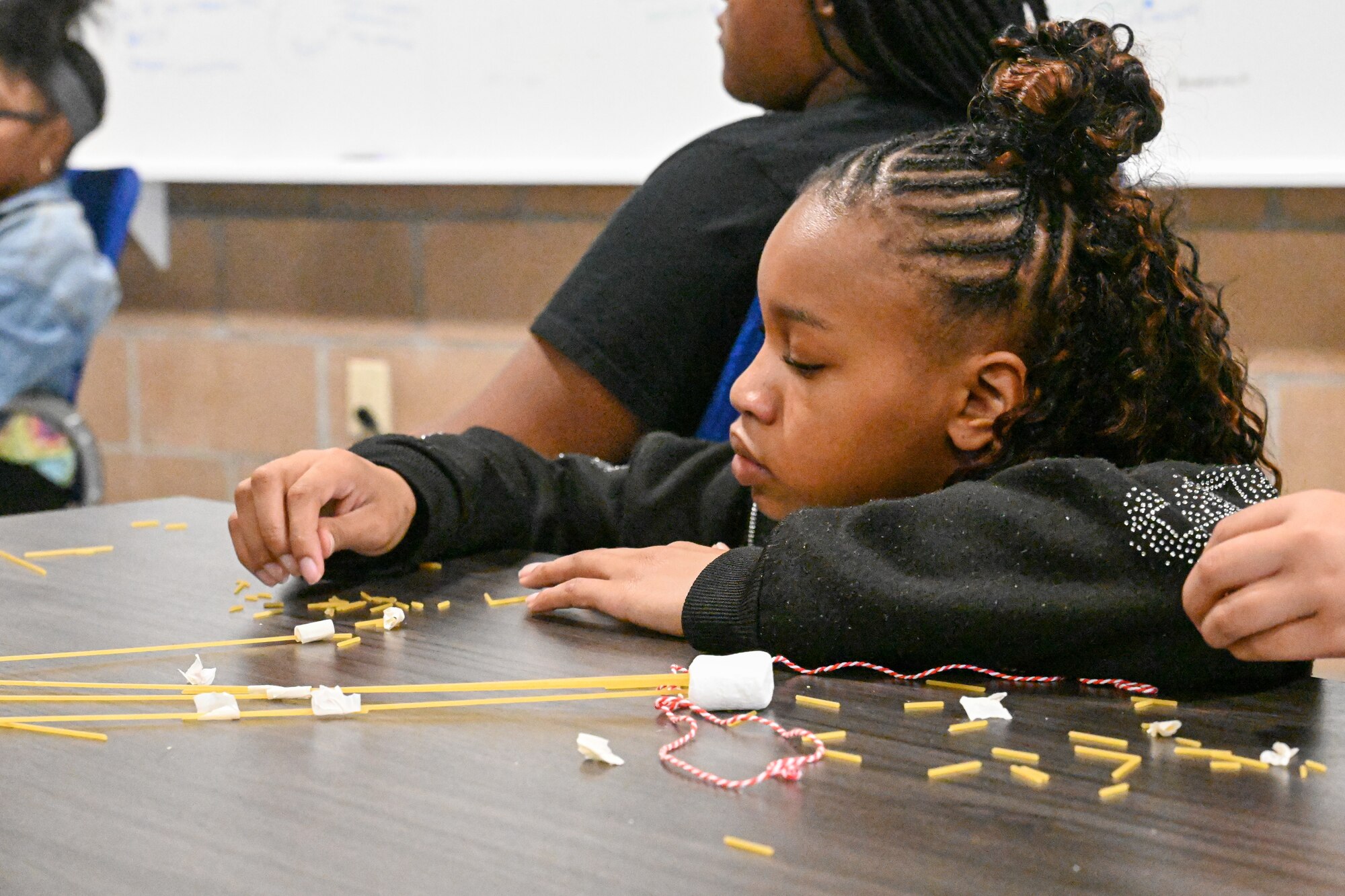 A child completes an activity at a table.