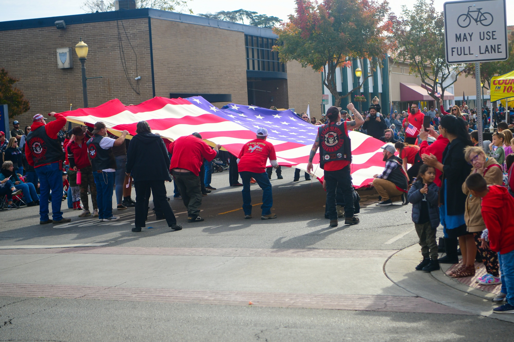 Parade participants wave the American flag during the Veterans Day parade in Marysville, Calif., on Nov. 11, 2022.