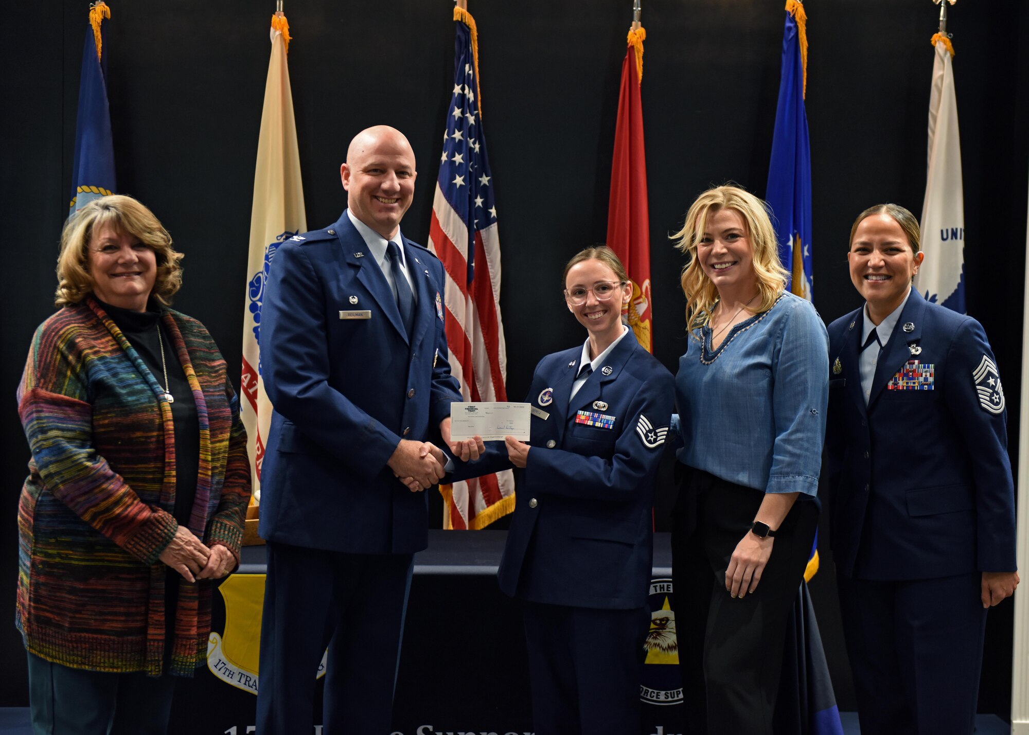The relatives of the late retired U.S. Air Force Col. Charles Powell, former 17th Training Wing commander, present the Powell Warrior Award to Staff Sgt. Taylor Serna, 316th Training Squadron instructor, at the Community College of the Air Force graduation in the Powell Event Center, Nov. 16, 2022. The award is presented to those who choose to continue education. (U.S. Air Force photo by Airman 1st Class Sarah Williams)