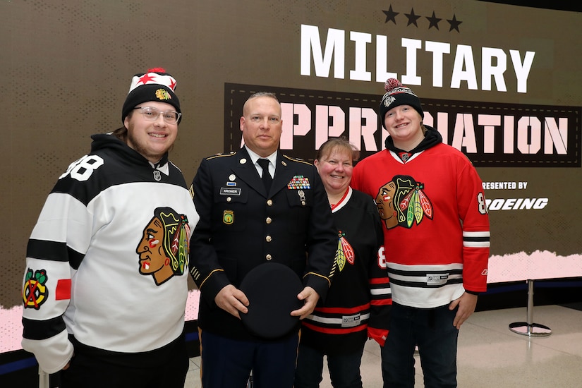 From left to right, Jacob, son of Kroner; U.S. Army Reserve Staff Sgt. Eric Kroner; Anna, wife of Kroner; and James, son of Kroner, pause for a photo during the Chicago Blackhawks Military Appreciation Night game on Monday, November 14, 2022, at the United Center in Chicago.
