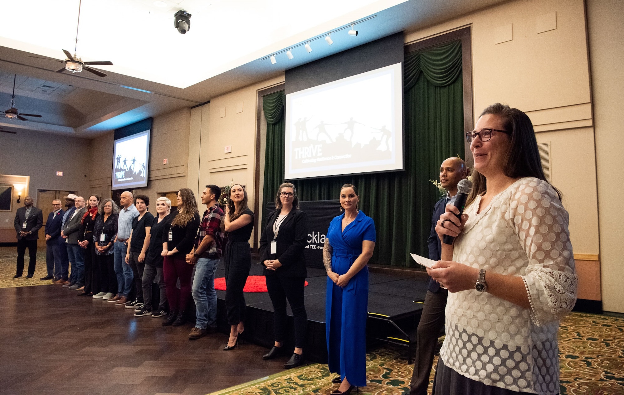 Col. Lauren Courchaine, speaks to the audience, while speakers look on, at the TEDx Joint Base San Antonio-Lackland, Texas, Nov. 4, 2022.